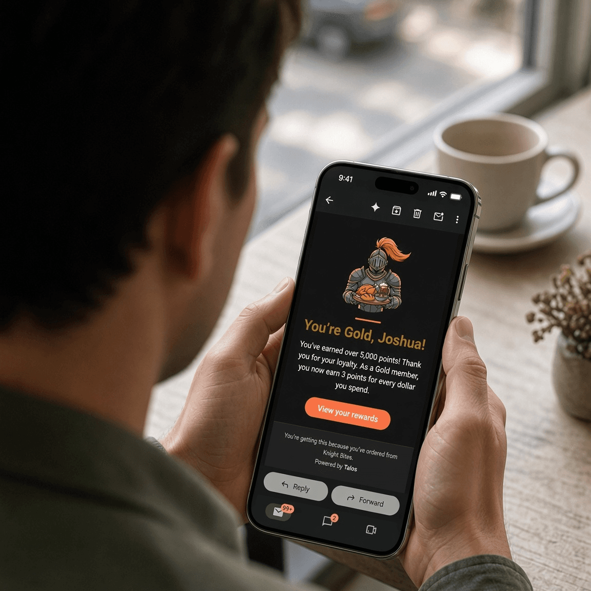 A customer reading a Knight Bites Gold rewards email on their phone